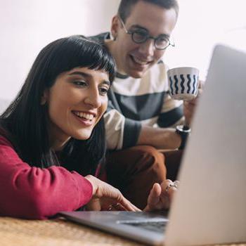 Couple looking at laptop smiling